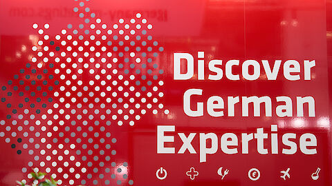 Rote Messewand mit Schriftzug "Discover German Expertise" | © GCB