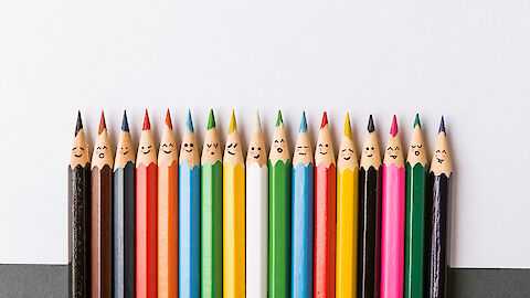 farbige Buntstifte mit aufgemalten Gesichtern | © iStock.com / vvmich